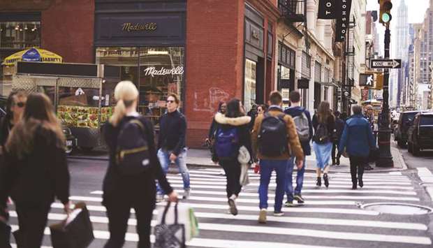 Shoppers and pedestrians cross a street in New York. Consumer spending, which accounts for more than two-thirds of US economic activity, rose 0.4% as households boosted purchases of motor vehicles and spent more at restaurants and on hotel accommodation.
