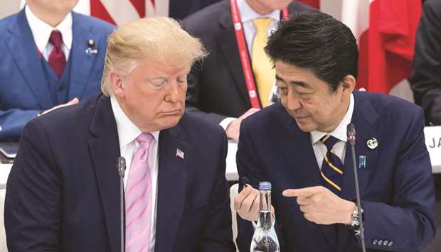 Japanu2019s Prime Minister Shinzo Abe (right) talks to US President Donald Trump as they attend a meeting on the digital economy at the G20 Summit in Osaka yesterday. Trump, while touting his close ties with Japan, has repeatedly criticised Tokyo for what he views as a trade imbalance, with the issue coming up during his bilateral talks with Abe.