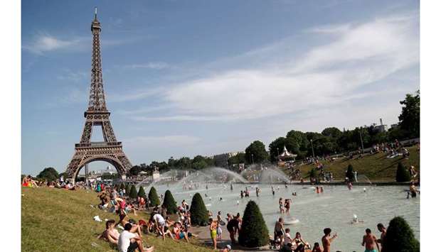 People bathe in the Trocadero Fountain near the Eiffel Tower in Paris during a heatwave.