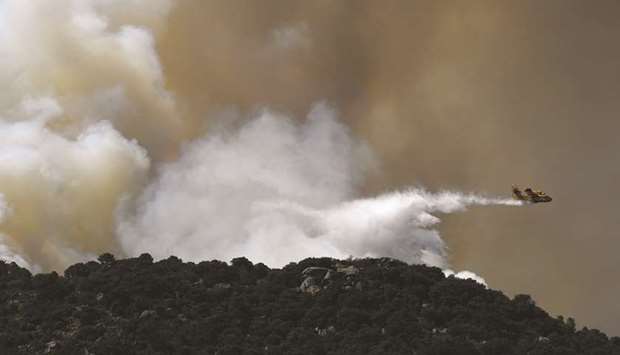 A Canadair plane drops water over a wildfire in the outskirts of Cenicientos, central Spain, yesterday.