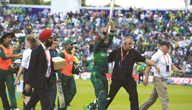 Pakistanu2019s Imad Wasim (centre) is escorted off the field by security officials after the win over Afghanistan in their 2019 Cricket World Cup match at Headingley in Leeds, United Kingdom, yesterday. Wasim took two wickets and scored an unbeaten 49 to be adjudged Man of the Match. (AFP)