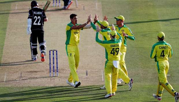 Australiau2019s Mitchell Starc (second from left) celebrates with teammates after taking the wicket of New Zealandu2019s Kane Williamson (left) during the 2019 ICC Cricket World Cup match at Lordu2019s Cricket Ground in London yesterday. (Reuters)