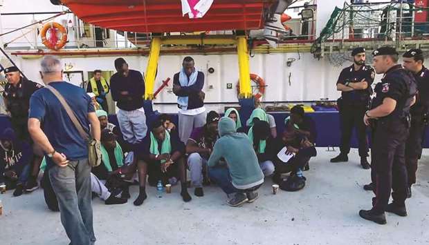 An image grab taken from a video shows migrants after they disembarked from the Sea-Watch 3 charity ship at the Italian port of Lampedusa. The Sea-Watch 3 carrying dozens of migrants rescued off Libya forced its way into the Italian port on Friday evening after a lengthy stand-off with Italian authorities.