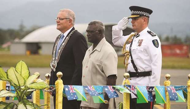 Australiau2019s Prime Minister Scott Morrison, left, is accompanied by Solomon Islandsu2019 Prime Minister Manasseh Sogavare as he inspects a guard of honour upon his arrival in Honiara yesterday.