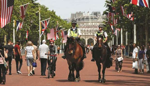 Police officers ride their horses as they patrol along the US and Union flag-lined Mall, leading to Buckingham Palace, in central London, yesterday, ahead of a visit to the UK by US President Donald Trump.