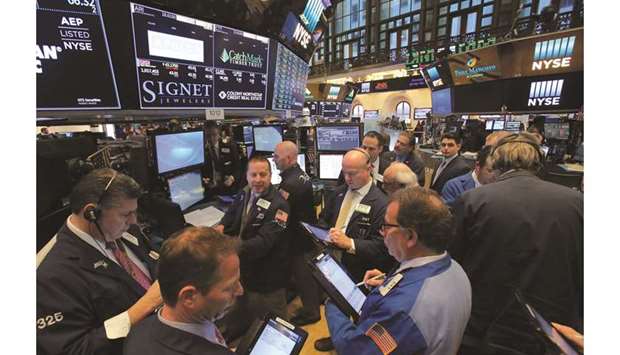 Traders work at the New York Stock Exchange (file). As traders seek protection against the collapse in stocks and bond yields hit new lows, strategists at Bank of America Corp and Morgan Stanley predict inflows into dividend funds.