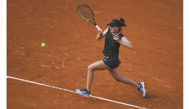 Polandu2019s Iga Swiatek returns the ball to Romaniau2019s Simona Halep.