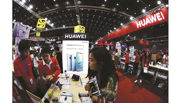 People visit the Huawei stand at the Mobile Expo in Bangkok. Huawei will sell its majority share in a submarine cable unit, the stakeu2019s buyer announced yesterday, amid a US-led drive to isolate the Chinese telecom giant from global information networks over spying fears.