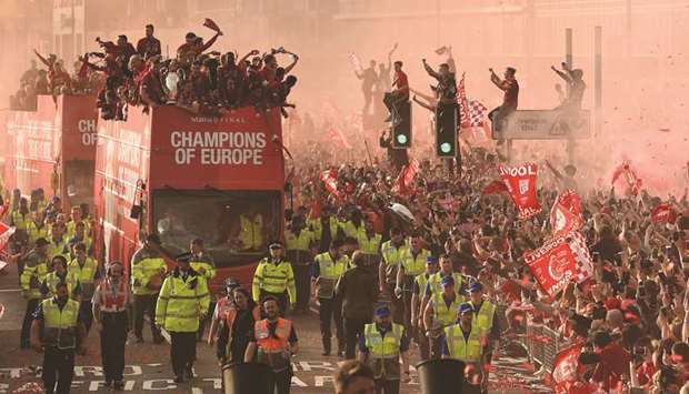Fans line the streets to see the Liverpool team take part in an open-top bus parade around Liverpool on Sunday, after winning Champions League title. (AFP)