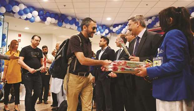 Pakistani officials welcome passengers of the British Airways flight with a rose upon their arrival at the Islamabad International Airport on the outskirts of Islamabad yesterday.