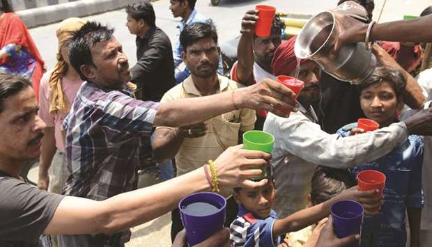 Volunteers distribute sweet water during a hot summer day, in Amritsar yesterday. Temperatures passed 50 degrees Celsius in northern India as an unrelenting heatwave triggered warnings of water shortages and heatstroke.