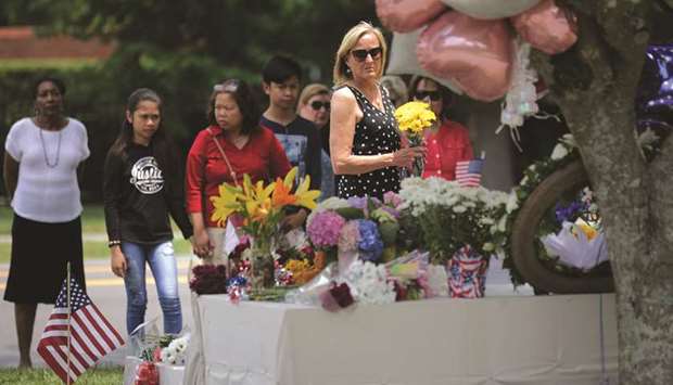 People place flowers at a makeshift memorial at the Municipal Center in Virginia Beach, Virginia.