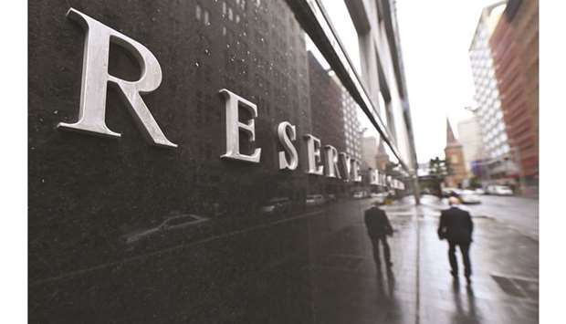 Pedestrians walk past the Reserve Bank of Australia building in Sydney. The RBA cut interest rates by 25 basis points to a historic low of 1.25%, as the pace of growth slowed to levels not seen since the global financial crisis.