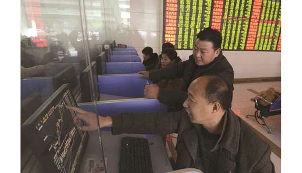 Investors look at a computer screen showing stock information at a brokerage house in China. The Composite closed down 1.0% to 2,862.28 points yesterday.