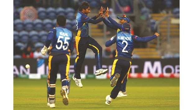 Sri Lankau2019s Nuwan Pradeep (2L) celebrates with teammates after taking the wicket of Afghanistanu2019s Rashid Khan for two runs at Sophia Gardens Stadium in Cardiff yesterday.