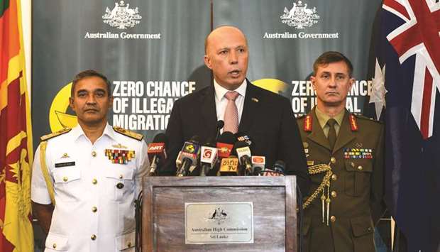 Australiau2019s Home Affairs Minister Peter Dutton, centre, speaks to the media as Sri Lankau2019s navy commander Piyal De Silva, left, and the head of Australiau2019s Operation Sovereign Borders Major General Craig Furini look on in Colombo yesterday.
