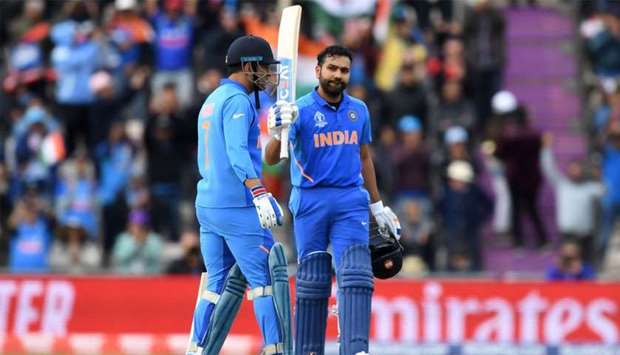 India's Rohit Sharma (R) celebrates with India's Mahendra Singh Dhoni on reaching his century during the 2019 Cricket World Cup group stage match between South Africa and India at the Rose Bowl in Southampton