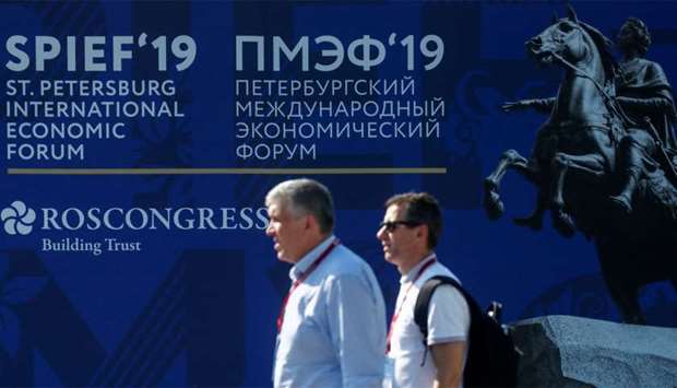 Participants walk next to the logo of the St Petersburg International Economic Forum (SPIEF) in St Petersburg, Russia