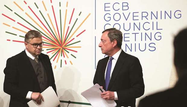 Vitas Vasiliauskas, governor of Lithuaniau2019s central bank (left), and Mario Draghi, ECB president, arrive for a rates decision news conference in Vilnius, Lithuania, yesterday. Draghi said policymakers had addressed the ECBu2019s readiness to act in case of u201cadverse contingencyu201d and several had raised the possibility in yesterdayu2019s discussion of further interest rate cuts or restarting asset purchases.