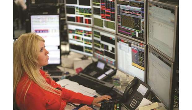 A trader monitors share prices at the London Stock Exchange. The FTSE 100 index closed 0.5% higher at 7,259.85 points yesterday driven by consumer goods stocks.