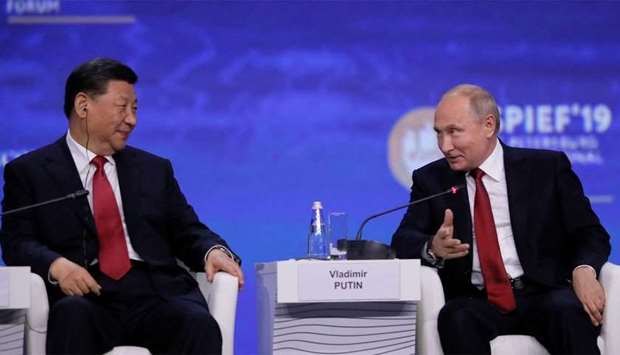 Russian President Vladimir Putin and Chinese President Xi Jinping attend a session of the St. Petersburg International Economic Forum