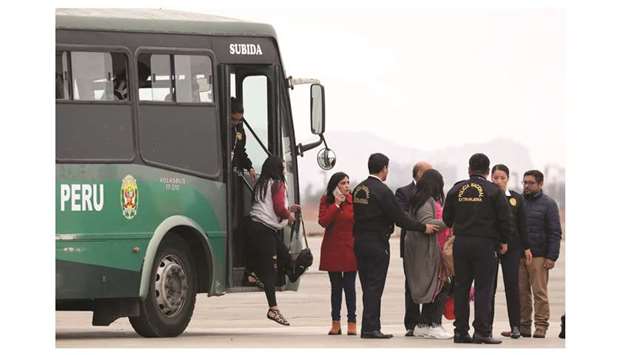 Peruvian immigration police escort Venezuelan migrants as they board a bus prior to their deportation, after being accused of concealing that they had criminal records,  according to Peruu2019s interior ministry, in Lima, Peru.