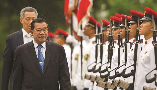 In this file photo, Cambodian Prime Minister Hun Sen (front) inspects an honour guard as Singaporeu2019s Prime Minister Lee Hsien Loong walks behind him at the Istana in Singapore.