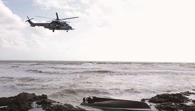 A helicopter flies over the sea and the capsized SNSM sea-rescue boat in Les Sables du2019Olonne.