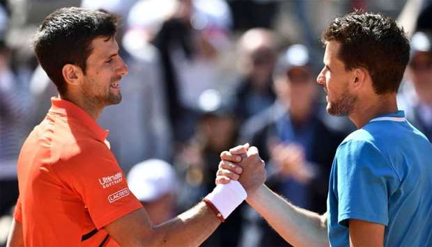 Austria's Dominic Thiem (R) and Serbia's Novak Djokovic shake hands at the end ofduring their men's singles semi-final match
