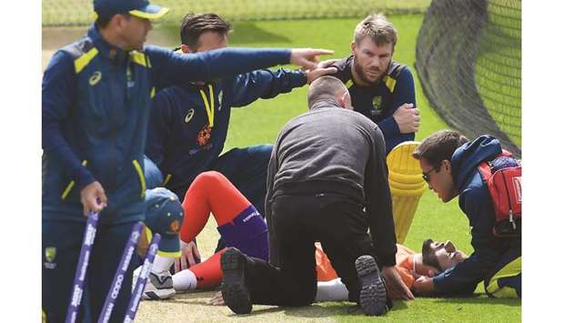 Australiau2019s David Warner (centre) looks on as an injured net bowler, Jaykishan Plaha, receives medical attention during nets at The Oval in London yesterday. (AFP)