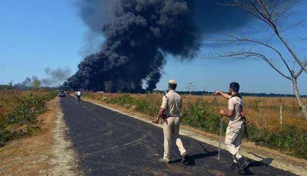 Police ask people to move to a safer place as smoke rises following an explosion at an oil well operated by the state owned Oil India Limited (OIL) in Baghjan, Tinsukia district of Assam yesterday.