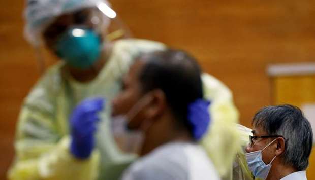 Essential workers have their noses swabbed before returning to the workforce at a regional screening center, amid the coronavirus disease outbreak in Singapore