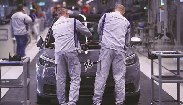 Employees secure a plastic hood fitting to a Volkswagen ID.3 electric automobile on the assembly line at the automakeru2019s factory in Zwickau, Germany. The ID.3u2019s success is vital for the worldu2019s biggest automaker to meet stricter emissions rules in Europe and get the industryu2019s largest push into electric vehicles off the ground.