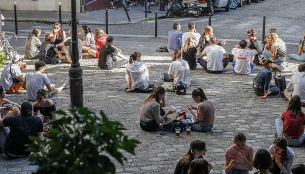 People sit and drink on a cobbled pavement in Paris over the weekend, ahead of the reopening of the French capitalu2019s cafe terraces.