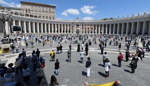 People maintain social distancing at St Peteru2019s Square while listening to Pope Francisu2019s u2018Regina Coeliu2019 prayer, led from his window for the first time since the coronavirus lockdown.