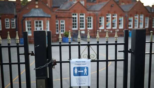 A social distancing sign is seen on the gate of a school as the spread of the coronavirus disease (COVID-19) continues in Hale, Britain