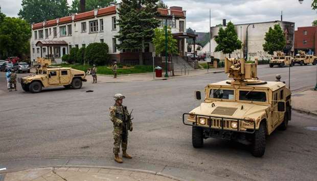 Minnesota National Guard soldiers patrol a street in Minneapolis, Minnesota, as protesters demand justice for George Floyd who died in police custody