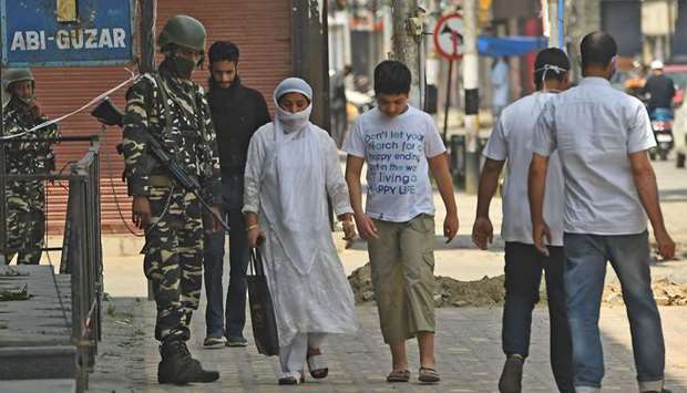 Paramilitary troopers stand guard as people walk through central Srinagar yesterday. India has escalated counter-insurgency efforts in Jammu and Kashmir.
