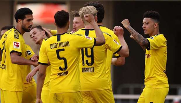 Dortmundu2019s English midfielder Jadon Sancho (right) is congratulated by his teammates after scoring his teamu2019s third goal during the Bundesliga match against SC Paderborn 07 at Benteler Arena in Paderborn yesterday. (AFP)