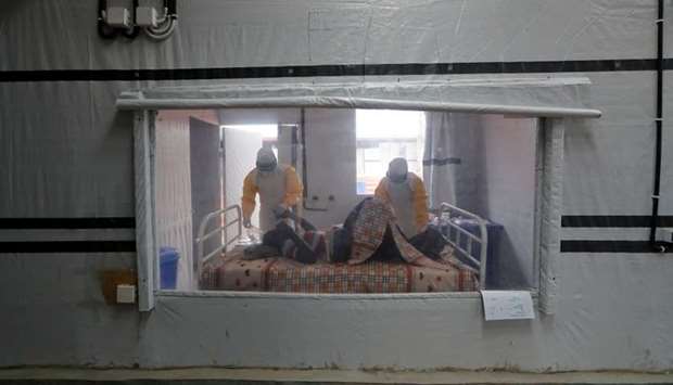 Moise Vaghemi, 33, (L) an Ebola survivor who works as a nurse cares for a patient who is suspected to be suffering from Ebola, inside the Biosecure Emergency Care Unit (CUBE) at the Ebola treatment centre in Katwa, near Butembo, in the Democratic Republic of Congo, October 3, 2019