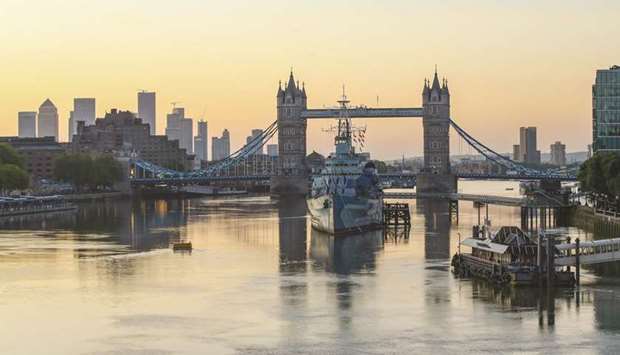 The sun rises beyond Tower Bridge in London. In a slump dwarfing previous downturns, the UK economy contracted by 20.4% in April from March, when it shrank by nearly 6%. It was 24.5% smaller than in April 2019.