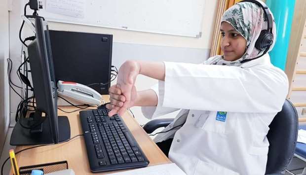A physiotherapist gives instructions to a patient online
