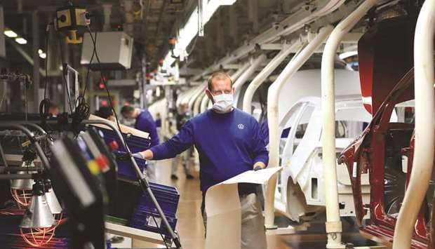 An automobile assembly line worker wears a protective face mask as Volkswagen restarted production at their headquarter factory in Wolfsburg, Germany, on April 27. After crashing to its lowest reading in the surveyu2019s nearly 22-year history in April, IHS Markitu2019s Manufacturing Purchasing Managersu2019 Index for the eurozone recovered somewhat last month, rising to 39.4 from 33.4.