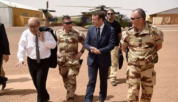 File photo taken on May 19, 2017 shows French President Emmanuel Macron and French Foreign Affairs Minister Jean-Yves Le Drian (left) visiting the troops of Franceu2019s Barkhane operation in Africau2019s Sahel region in Gao, northern Mali.