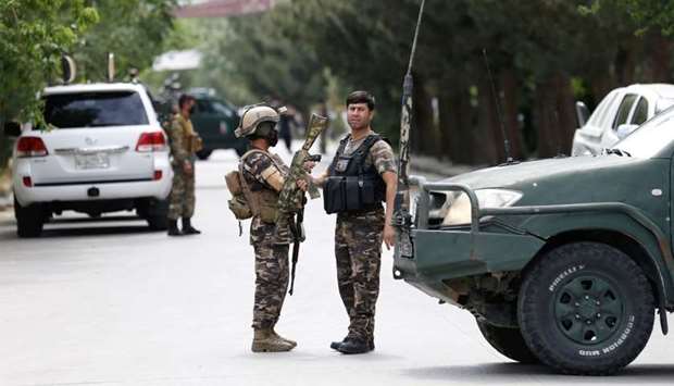 Afghan security forces stand guard near the site of an attack in Kabul, Afghanistan