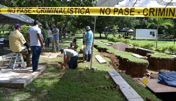 Forensic experts take part in the exhumation of the remains of people killed during the US invasion of Panama in 1989, at the Jardin de Paz cemetery in Panama City.
