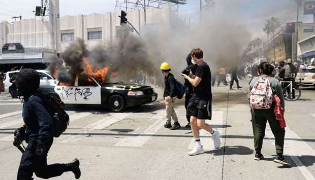 An LAPD vehicle burns after being set alight by protestors during demonstrations following the death of George Floyd in Los Angeles, California