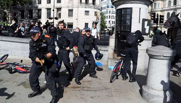 Police officers protect an injured man who was attacked during a Black Lives Matter protest in Londonu2019s Trafalgar Square.