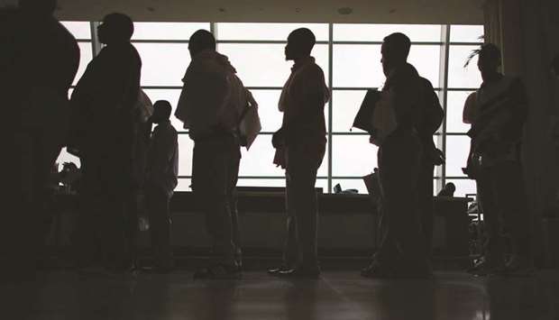 People looking for work stand in line to apply for a job during a job fair at the Miami Dolphins Sun Life stadium in Miami, Florida (file).