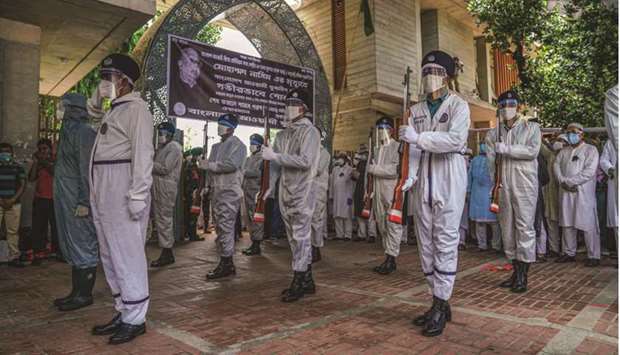 A guard of honour (foreground) pays tribute to late Awami League leader and former health minister Mohamed Nasim as AL officials and activists (background) attend his burial at the Banani graveyard in Dhaka yesterday.